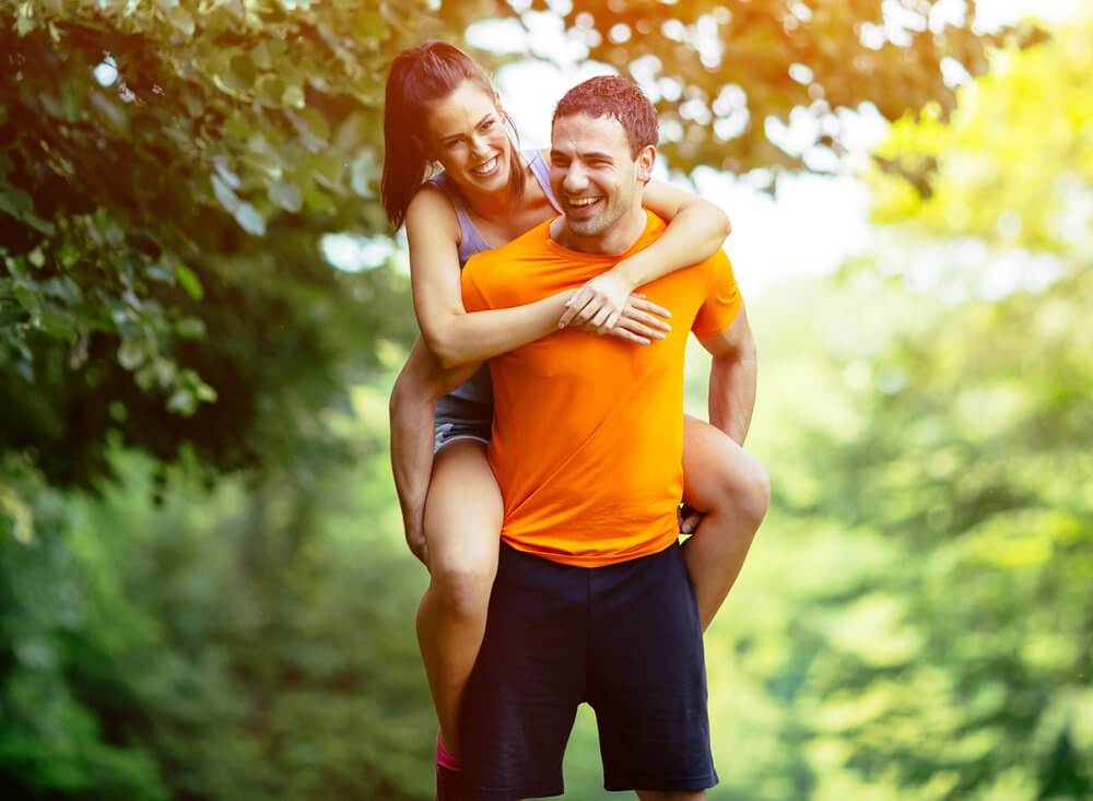Diet Guide - Fruitarian Diet - Fruit Diet - Low-Fat Raw Vegan Diet - Man Playfully Carries Partner In Nature - Fruit-Powered