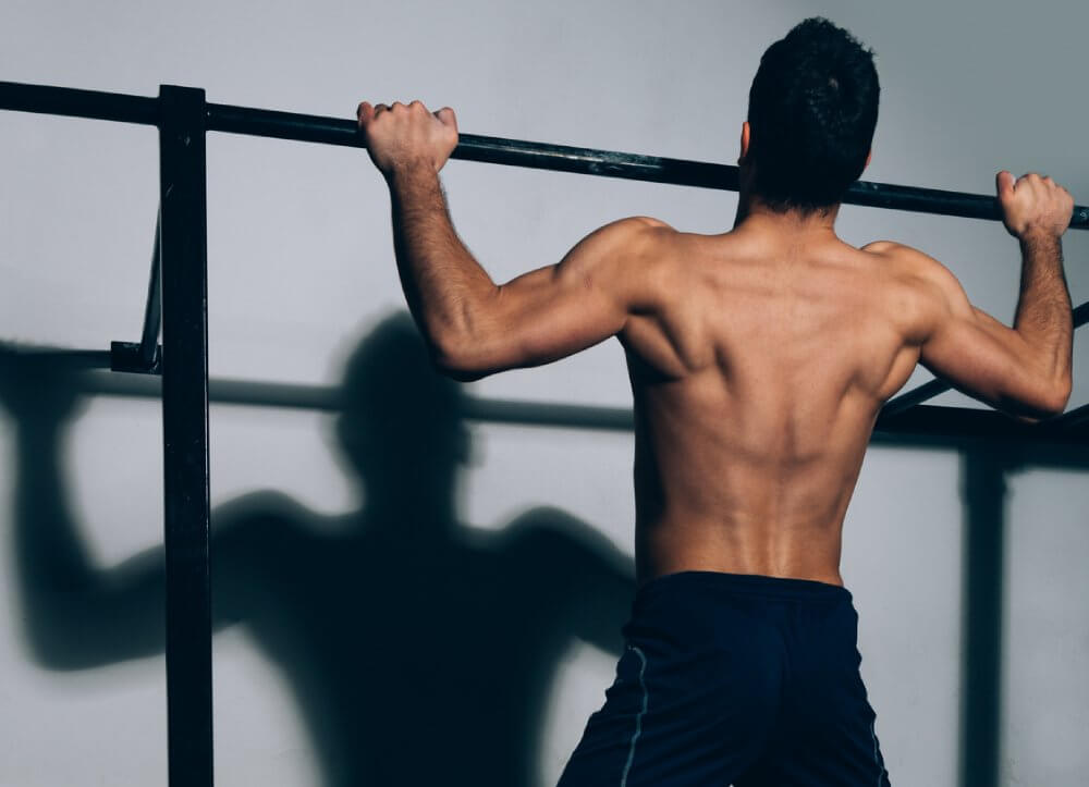 Exercise Guide - Posture Correction Exercises - Calisthenics - Peak Health - Man Doing Pull-Ups - Fruit-Powered