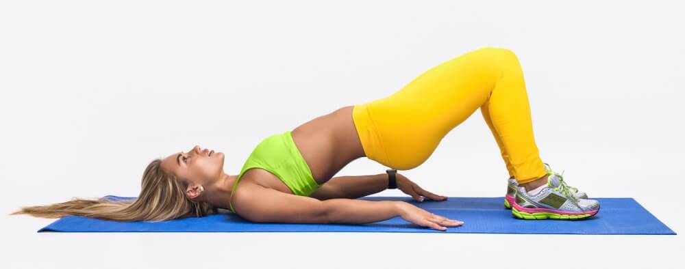 Exercise Guide - Posture Correction Exercises - Calisthenics - Peak Health - Woman Practicing Bridge Pose - Fruit-Powered