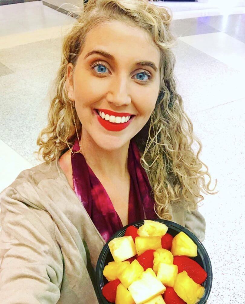 Caileigh Feldman - top 5 tips for surviving airports as a raw vegan - holding fruits - Fruit-Powered