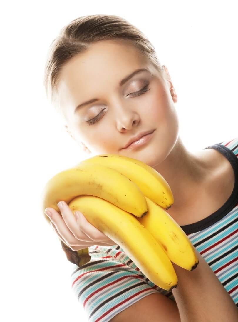 How to be successful on a raw vegan diet - woman with eyes closed holding bananas - Fruit-Powered