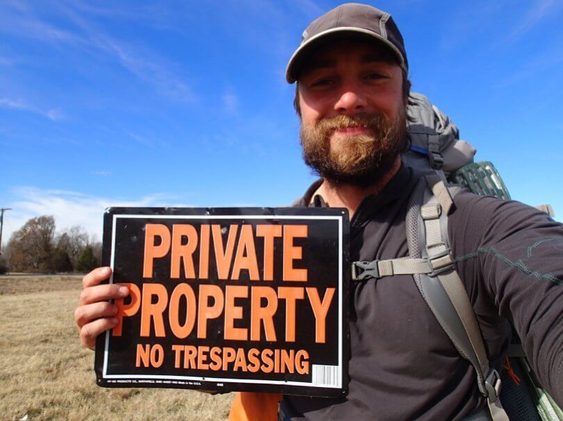 Ken Ilgunas holding private property sign - This Land Is Our Land - vandwelling - wanderlust - society - Fruit-Powered