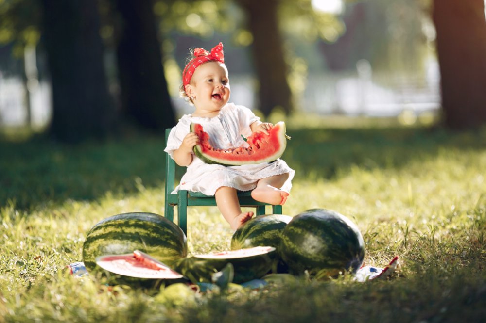 Importance of eating organic fruit - girl eating watermelon in a park - Fruit-Powered