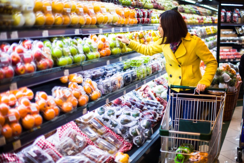 Importance of eating organic fruit - woman shopping for produce in a supermarket - Fruit-Powered