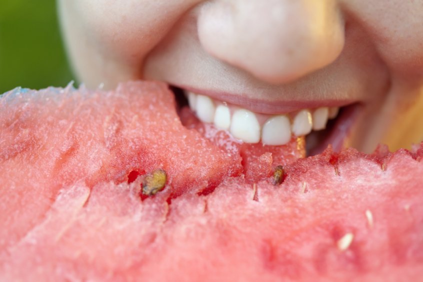 Are humans really omnivores - woman with teeth biting into watermelon - Fruit-Powered