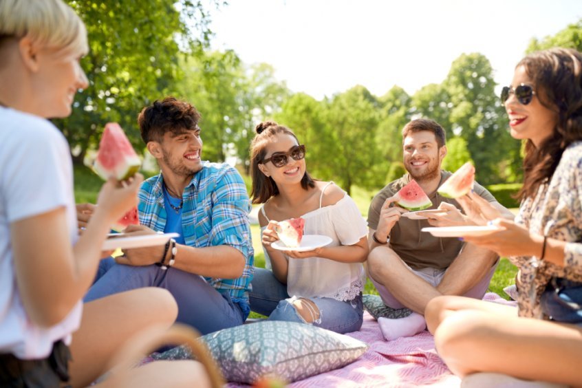 Modern-day raw food movement history - friends eat at a fruit potluck - Fruit-Powered